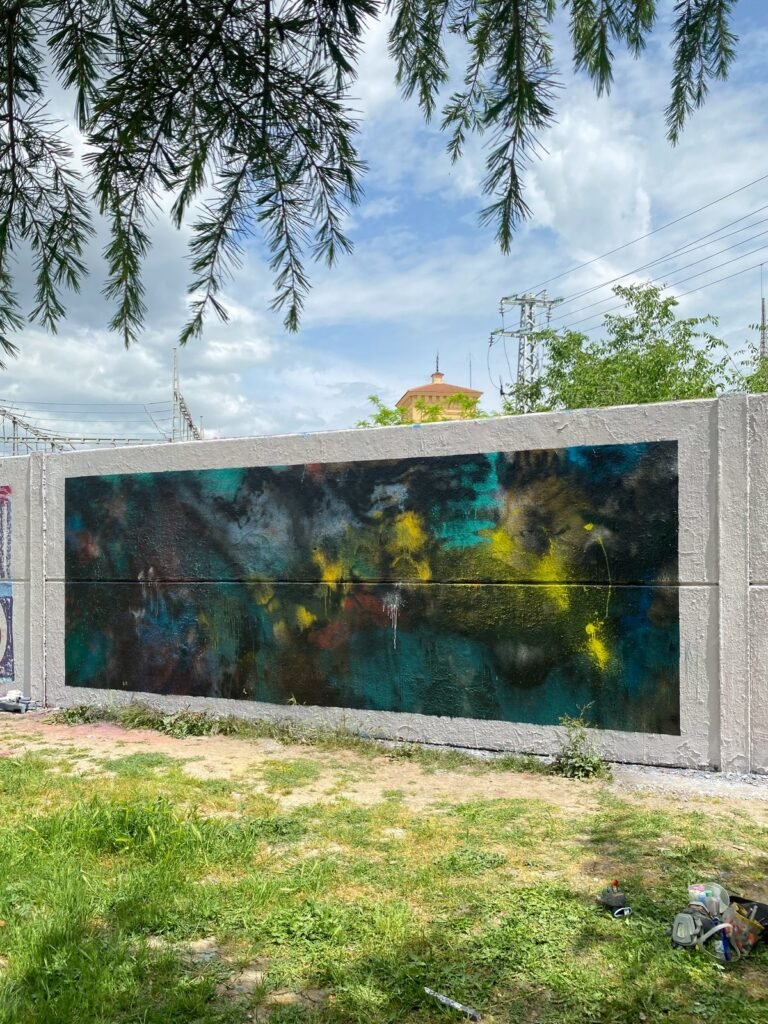 El panel con el fondo en oscuros visto en escorzo, con ramas de un árbol colgando en primer plano.