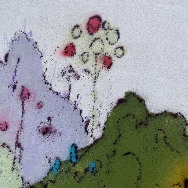 Detalle del mural: flores rojas y la textura punteada del spray sobre una montaña malva y verde