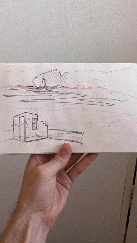 Una mano sostiene el boceto a lápiz: el arco de roca arriba y las paredes dibujadas debajo.