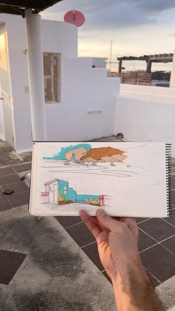 Una mano sostiene el boceto en color delante de las paredes todavía blancas.