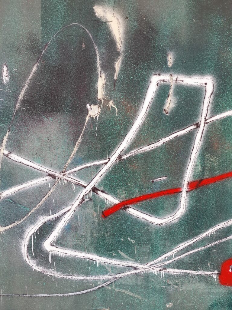 Detalle de trazos blancos y un trazo rojo sobre la persiana verde