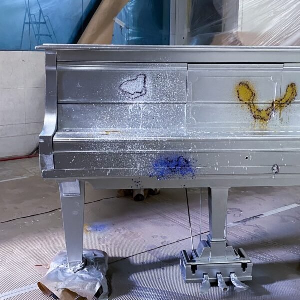 Base de pintura plata recién aplicada sobre el piano de cola Hardman, en el taller