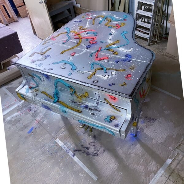 Vista aérea del piano de cola Hardman con las conexiones rotas de color pintadas sobre el cuerpo entero