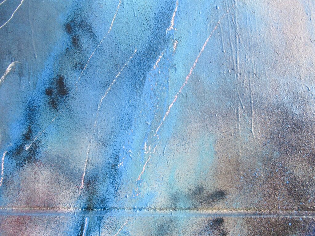 Detalle de la pintura: azules, rosas y negros con arañazos blancos y la junta del muro