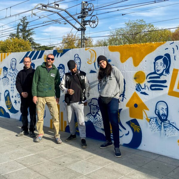 Cuatro personas delante del mural terminado «50 años en libertad» en Fuenlabrada.