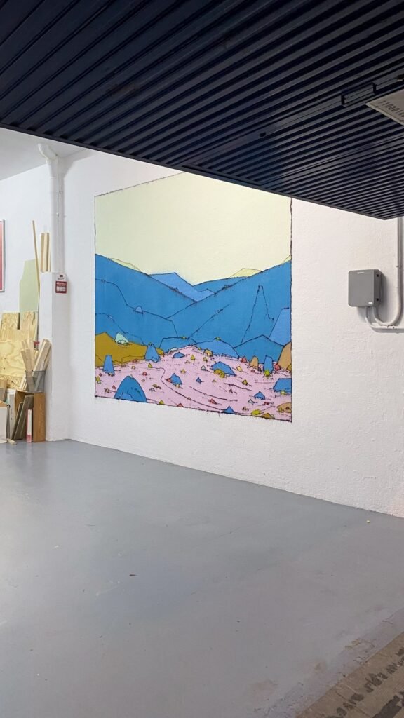 El mural Valle Peseta al fondo de la nave de Espacio Peseta, con el techo negro y el suelo gris en primer término.