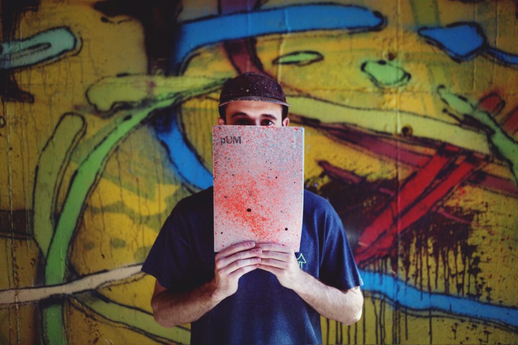 Una persona sostiene el fanzine Pum delante de la cara, frente a un muro pintado