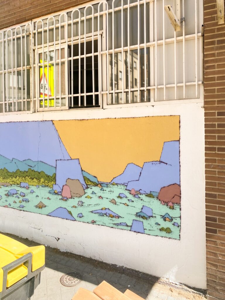 Vista oblicua de Al alba, con la reja de la ventana y la señal de colegio sobre el muro.