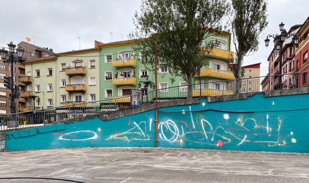 El muro turquesa con los primeros trazos blancos y de colores.