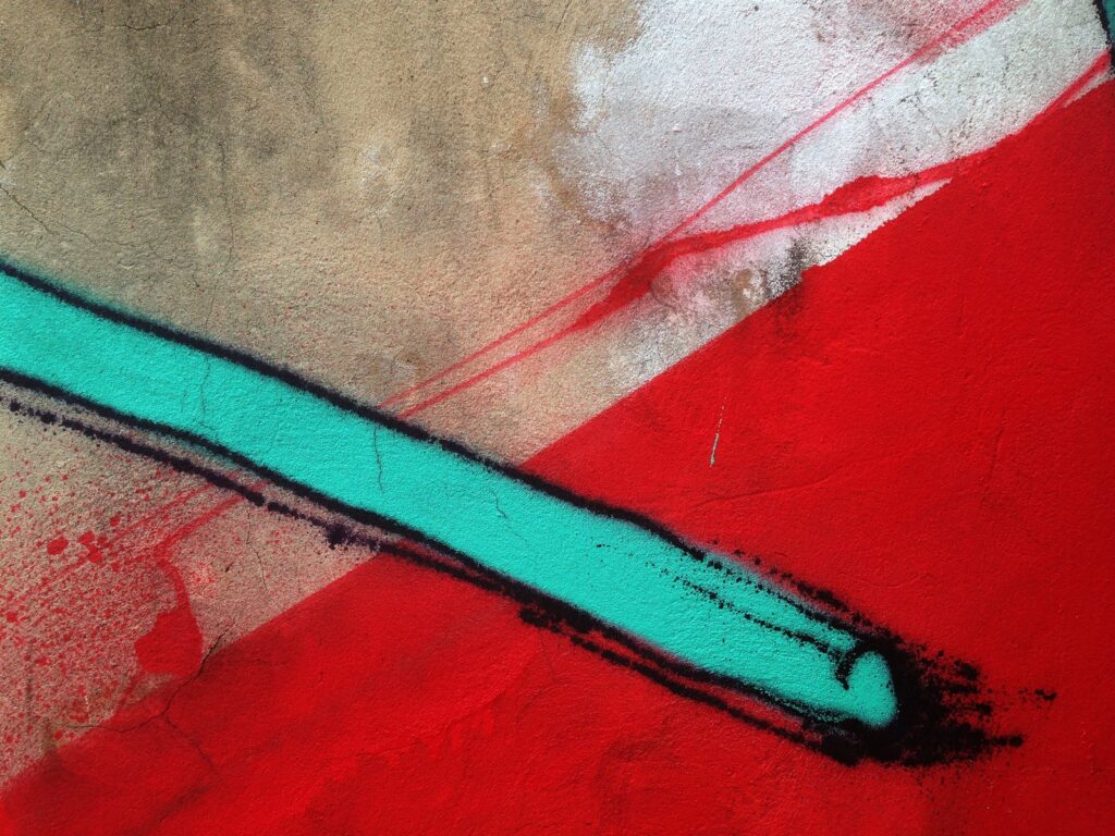 Una barra turquesa con borde negro cruza el triángulo rojo y la pared gris.