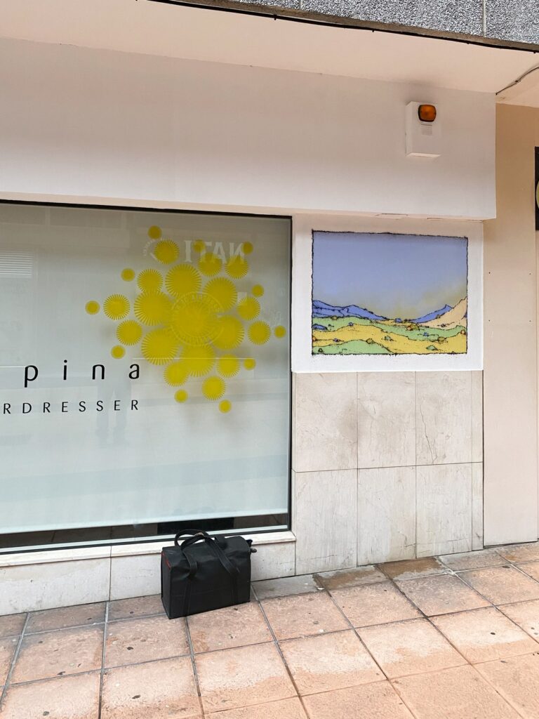 El mural ya pintado y rodeado por su marco blanco, en la pared de la fachada.