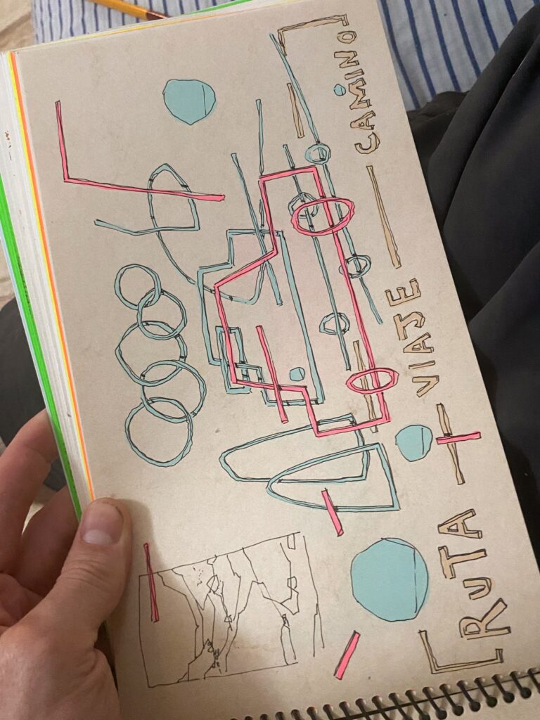 Una libreta abierta con el dibujo del coche en rotulador y las palabras «Ruta», «Viaje» y «Camino».