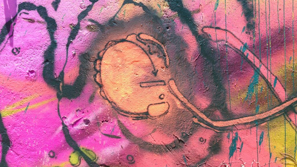 Detalle de un círculo naranja con trazos oscuros sobre un fondo rosa y magenta.